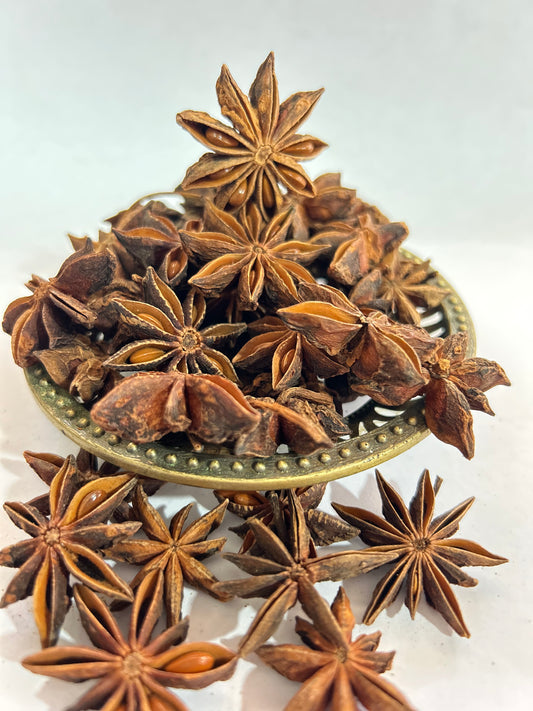 A close-up of star anise pods with seeds, showcasing their unique star shape and rich brown color.